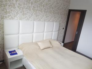 ポイアナ・ブラショフにあるApartment Poiana Brasovのベッドルーム(白いベッド1台、鏡付)