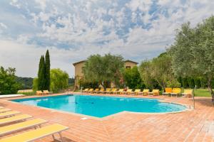 a large swimming pool with chairs at Le Camere del Relais La Pieve Vecchia in Riparbella
