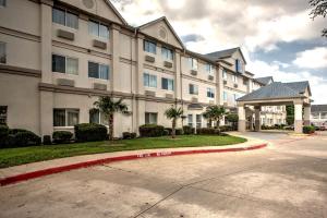 a large building with palm trees in front of it at Motel 6-Dallas, TX - Northwest in Dallas