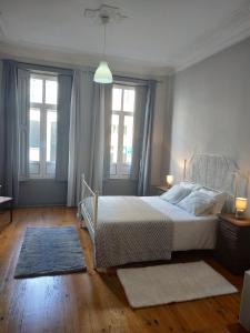 um quarto com uma cama e duas janelas em Gabriel Guesthouse no Porto