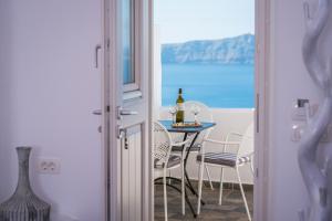 a dining room with a table with a bottle of wine at Angel Luxury Suites in Fira