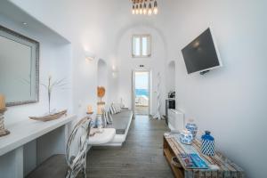 a white bathroom with a television and a table at Angel Luxury Suites in Fira