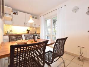 グラール・ミューリッツにあるModerne Ferienwohnung in Graal-Müritz, strandnahのテーブルと椅子のあるキッチンとダイニングルーム