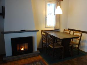 a dining room with a fireplace and a table and chairs at Residenza Paradiso di Vacanze in Locarno