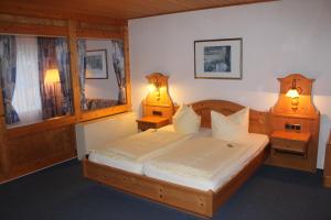 a bedroom with a bed with two lamps on two tables at Waldhotel Dornröschenshöh in Hemfurth-Edersee