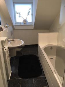 a bathroom with a sink and a tub and a window at Zur Burgmauer in Welschbillig