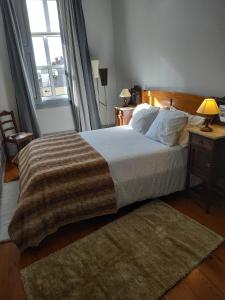a bedroom with a bed and a large window at Gabriel Guesthouse in Porto