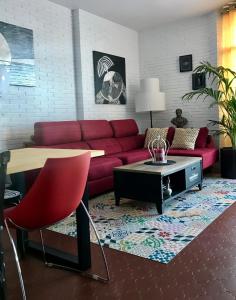 salon z czerwoną kanapą i stołem w obiekcie Torre de la Roca INDUSTRIAL69 w mieście Torremolinos