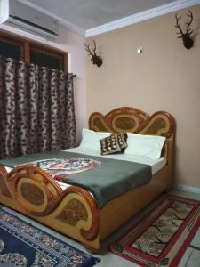 a bedroom with a bed with a wooden head board at Pratibha Home stay in Jabalpur