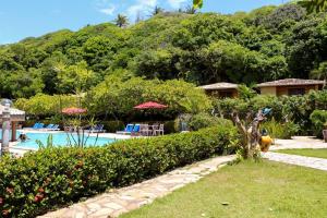 a resort yard with a swimming pool and trees at Pousada do Forte in Barra do Cunhau