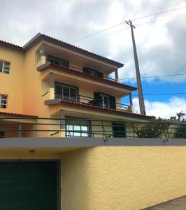 un gran edificio amarillo con balcón en la parte superior en Apartamento Reis Magos, en Caniço