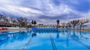 a large blue swimming pool with a building in the background at Hotel Molino De Saydo in Mollina
