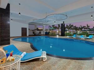 una gran piscina con sillas azules y un complejo en The Fern Residency, Bhuj en Bhuj
