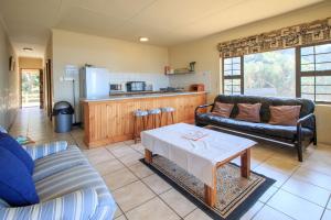 ein Wohnzimmer mit einem Sofa und einem Tisch in der Unterkunft Neptunes Cove in Kei-mouth Village