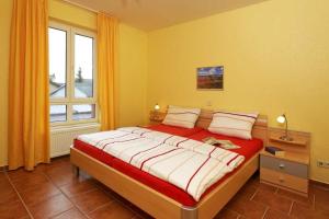 a bedroom with a large bed in a room with a window at Haus Grete Wohnung 14 in Ostseebad Koserow