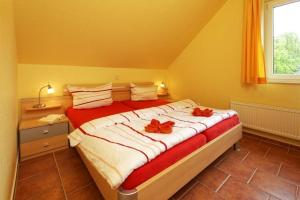 a bedroom with a large bed with red bows on it at Haus Grete Wohnung 15 in Ostseebad Koserow