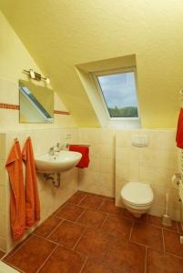 a bathroom with a sink and a toilet and a window at Haus Grete Wohnung 15 in Ostseebad Koserow