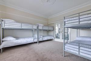 a room with three bunk beds in it at Serpentine Rose in Albany