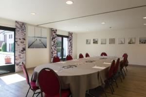 uma sala de conferências com uma mesa longa e cadeiras em The Originals City, Hôtel Le Gayant, Douai (Inter-Hotel) em Douai