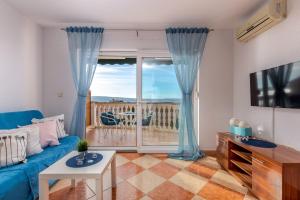 a living room with a blue couch and a window at Apartments Villa Maria in Crikvenica