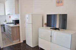 una cucina con frigorifero bianco e una TV su un bancone di Casa Chiara Verona a Verona