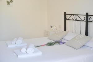 Una cama blanca con toallas y flores. en Casa Chiara Verona, en Verona