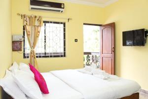 two beds in a room with a window at Sea View Resort in Patnem