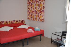 um quarto com uma cama vermelha e um cobertor vermelho em B&B La Via dell'Ambra em Due Carrare