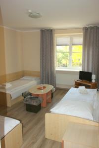 塞伊內的住宿－多姆利特斯基酒店，酒店客房设有两张床和一张桌子。