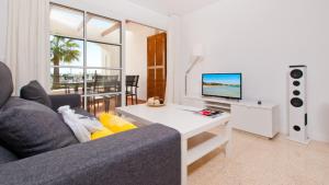 a living room with a couch and a table with a tv at Apartamento Blue Carabela in Alcudia