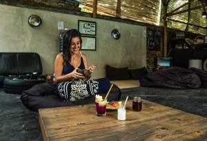 a woman sitting on a bean bag chair looking at her cell phone at Losmanos Hostel in Yogyakarta