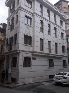 Biały budynek z samochodem zaparkowanym przed nim w obiekcie Golden Arrow 3 w Stambule