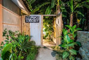 una entrada a un jardín con un cartel que lee los masyos yogas en Losmanos Hostel en Yogyakarta