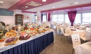 una grande stanza con un tavolo con sopra del cibo di Hotel Capinera a Rimini