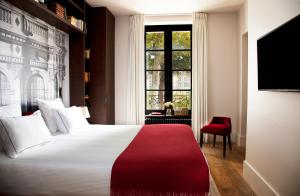a hotel room with a large bed and a window at Relais de Chambord - Small Luxury Hotels of the World in Chambord