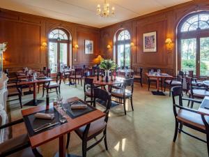 a restaurant with wooden walls and tables and chairs at Garrigae Manoir de Beauvoir Poitiers Sud - Hotel & Spa in Mignaloux-Beauvoir