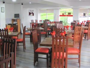 un ristorante con tavoli e sedie in legno con archi rossi di Shinic Holiday Inn a Nuwara Eliya