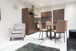Una sala de estar con mesa y sillas y una cocina. en Quay Apartments Clarence House, en Newport