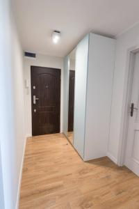 pasillo con puerta de cristal y suelo de madera en Studzienna, en Wroclaw