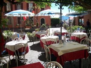 a group of tables and chairs with umbrellas on a patio at Albergo Il Vapore in Menaggio