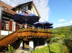 deux parasols bleus assis sur une terrasse en bois dans l'établissement Hotel Restaurant Adler Bühlertal, à Bühlertal