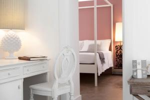 a bedroom with a white chair and a desk with a mirror at Mantatelurè in Lecce