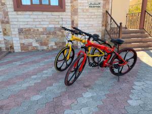 two bikes are parked next to a building at Stone Guest House in Al ‘Aqar