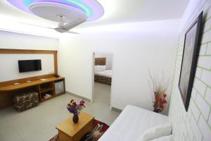 sala de estar con cama y TV en Nagar Valley Hotel Ltd., en Dhaka