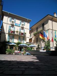 a large building with flags in front of it at Albergo Il Vapore in Menaggio