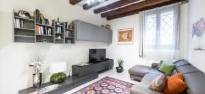uma sala de estar com um sofá e uma televisão em Cà Mocenigo Suite em Veneza