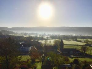 a view of a town with the sun in the sky at Coniston Cottage Lake View in Coniston