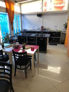 a large kitchen with a table and a table and chairs at Vila Blue Lagoon in Eforie Nord