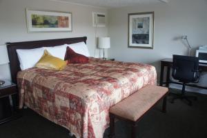 1 dormitorio con 1 cama grande con almohadas rojas y amarillas en Motel Clair Mont, en Sainte-Agathe-des-Monts