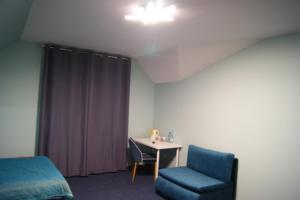 Zimmer mit einem Bett, einem Tisch und einem Stuhl in der Unterkunft Villa Tymotka in Lublin
